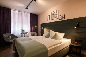 a hotel room with a large bed and a window at Hotel Mirabell by Maier Privathotels in Munich