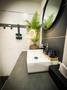 a bathroom with a white sink and a mirror at Deine-Ferienwohnung in Mahlberg