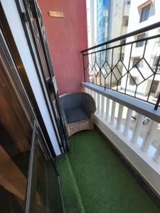 a balcony with a chair and a green floor at Fully furnished one bedroom apartment in Mombasa VOK off nyali road in Mombasa