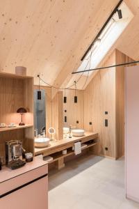 a bathroom with two sinks and wooden walls at SCHILCHERLANDLEBEN - Hochgrail in Greisdorf