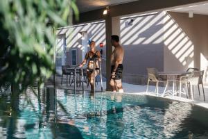 Zwei Männer stehen neben einem Schwimmbad. in der Unterkunft Skagen Strand Holiday Center in Hulsig