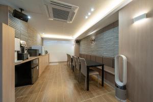 een keuken met een tafel en stoelen in een kamer bij Hound Hotel Gimhae Samgye in Gimhae