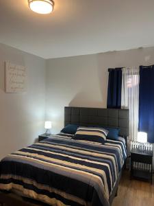 a bedroom with a large bed with blue curtains at Luxurious townhouse near nyc in Newark