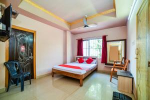 um quarto com uma cama, uma cadeira e uma janela em Flagship Hotel Mayur em Dalaigaon