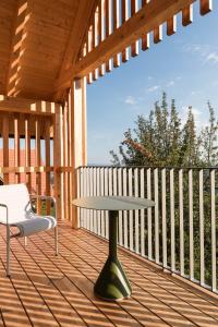 a table and a chair on a wooden deck at SCHILCHERLANDLEBEN - Hochgrail in Greisdorf