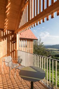 a wooden deck with a table and chairs on it at SCHILCHERLANDLEBEN - Hochgrail in Greisdorf