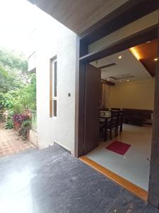 eine offene Tür eines Hauses mit einem Esszimmer in der Unterkunft oakwood mahabaleshwar in Mahabaleshwar