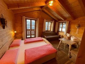 1 dormitorio con 2 camas en una cabaña de madera en Glinzhof Mountain Natur Resort Agriturismo, en San Candido