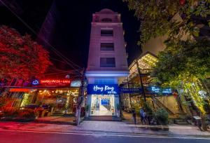 a building with a clock tower on a street at night at Cat Ba Hongkong Hotel in Cat Ba