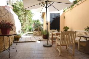 a table and chairs with an umbrella on a patio at Villa Maxim in Corfu Town in Corfu