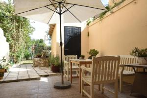 a table and chairs with an umbrella on a patio at Villa Maxim in Corfu Town in Anemómylos
