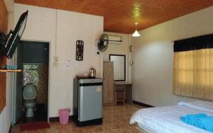 a bedroom with a bed and a kitchen with a sink at Prabpluem Resort in Chiang Klang