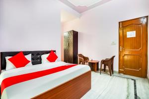 a bedroom with a bed and a door at OYO Hotel Royal Inn in Faridabad