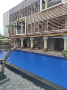 a large swimming pool in front of a building at Sinergi Hotel & Villa in Sengkaling