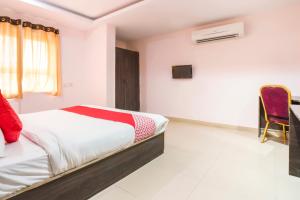 a bedroom with a bed and a desk and a chair at SPOT ON Hotel Sunshine Inn in Hyderabad