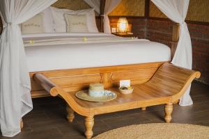 - une chambre avec un lit et un banc avec des chapeaux dans l'établissement Bali Palms, Tabanan, à Tabanan