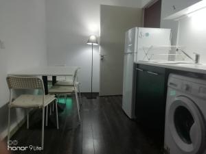 コッキニ・カニオンにあるNectus apartmentのキッチン(洗濯機、テーブル、椅子付)