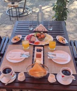 uma mesa com pratos de comida e chávenas de café em Pine View Hotel (Okella) em Saittas