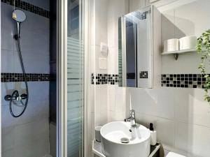 uma casa de banho branca com um lavatório e um chuveiro em Le petit Sartrouville à 20 min de Paris en RER A em Sartrouville