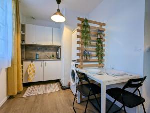 uma cozinha com mesa e cadeiras num quarto em Le petit Sartrouville à 20 min de Paris en RER A em Sartrouville