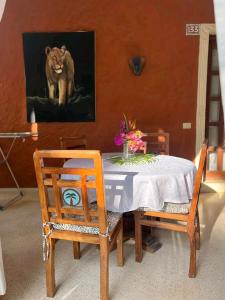 una mesa con dos sillas y una foto de un león en Beach front villa in Malindi en Malindi