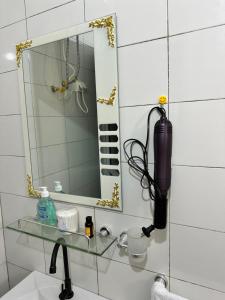 a bathroom with a mirror and a sink at Résidences PRIMIS Thiès - appartements et chambres in Thiès