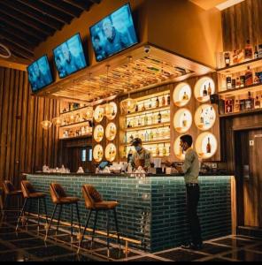 a man standing at a bar in a restaurant at Beach Dream - a luxury 1 bedroom apartment with direct beach access in Ras al Khaimah