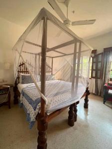 a canopy bed in a bedroom with a ceiling at Beach front villa in Malindi in Malindi