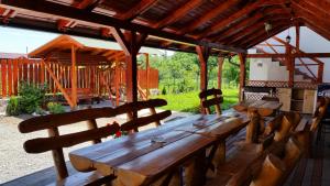 a wooden table and chairs under a pavilion at Casa Agnes Vendeghaz in Fîntînele