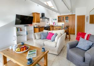 a living room with two couches and a table at Gartree Cottage in Fowey
