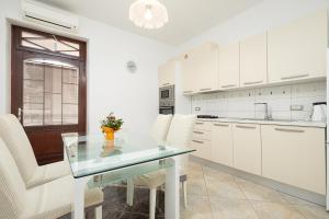 a kitchen with a glass table and white cabinets at Valnea - apartment for five people in the center of Poreč in Poreč