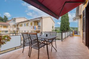 a patio with a table and chairs on a balcony at Valnea - apartment for five people in the center of Poreč in Poreč