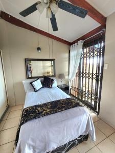 a bedroom with a bed and a ceiling fan at Seaview Villa 26 in Margate +16 photos