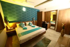 1 dormitorio con 1 cama con pared verde en Hotel Regency Inn, en Erode