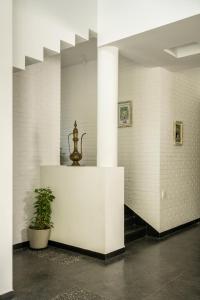 Cette chambre est dotée de murs blancs et d'un pilier avec une plante. dans l'établissement La Macedo Estate, à Mapusa