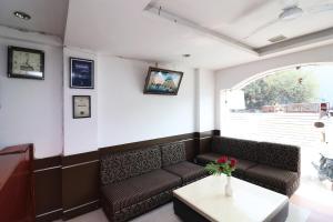 una sala de espera con sofá y mesa en Hotel Gud Stay, en Bhopal