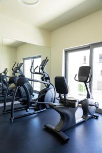 a gym with several tread machines in a room at New fully serviced 1BR Apartment in Al Ain