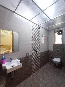a bathroom with a sink and a toilet and a mirror at oakwood mahabaleshwar in Mahabaleshwar