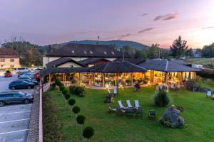 a building with a yard with chairs and a car at B&B Restoran Bosiljevo in Bosiljevo