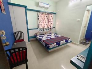ein kleines Schlafzimmer mit einem Bett und einem Stuhl in der Unterkunft Sree Theja Residency in Anantapur