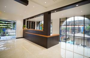 a lobby with large windows and a counter at 7 The Business Hotel in Alwaye