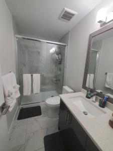 ein Bad mit einer Dusche, einem WC und einem Waschbecken in der Unterkunft Lux Modern 2BR Radiant Suite+Free Parking in Delta