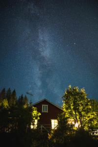 a house with the milky way in the night sky at Kotatuli Forest Lodge in Rovaniemi