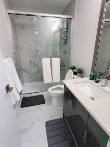 ein Bad mit einer Dusche, einem WC und einem Waschbecken in der Unterkunft Lux Modern 2BR Radiant Suite+Free Parking in Delta