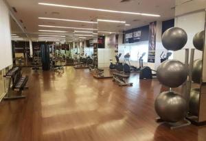 einen Fitnessraum mit Holzboden und Trainingsgeräten in der Unterkunft Arva Home in Surabaya