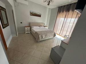 1 dormitorio con cama y ventana grande en Hotel Le Pinede Vistamare, en Pozzuoli