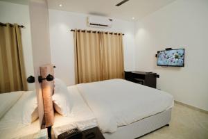 um quarto com uma cama e uma televisão em 7 The Business Hotel em Alwaye