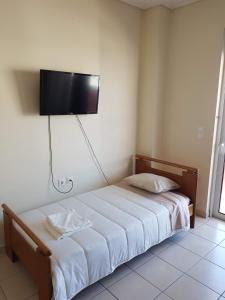 1 dormitorio con 1 cama y TV de pantalla plana en la pared en City center luxury studio en Karistos