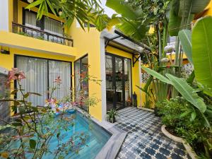 a house with a swimming pool in a garden at Hoi An Rosie Villa - 2 Bedrooms with Private Pool and Local Hoi An Decor in Hoi An