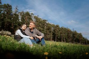 Un uomo e una donna seduti in un prato di Hotel Dirsch Wellness & Spa Resort a Emsing